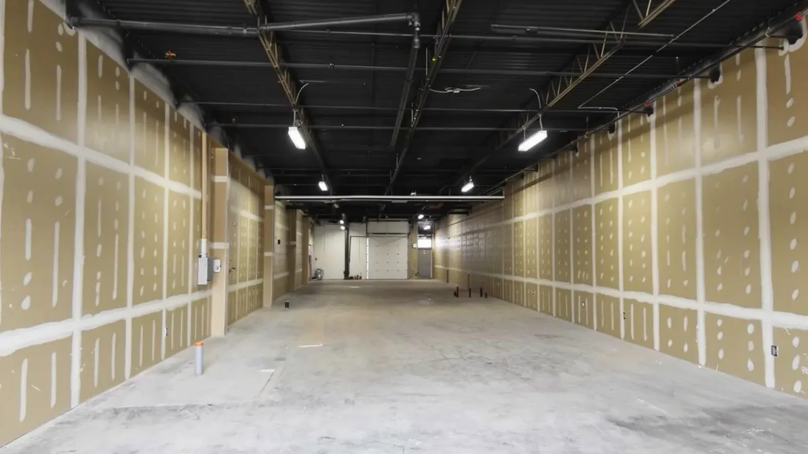 Fire-rated drywall demising walls taped from floor to deck in a commercial interior